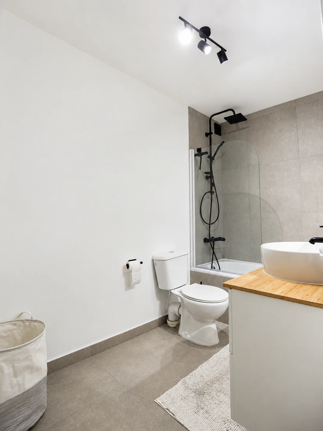 Ligbad met zwarte regendouche in de badkamer van De Duinring Wenduine